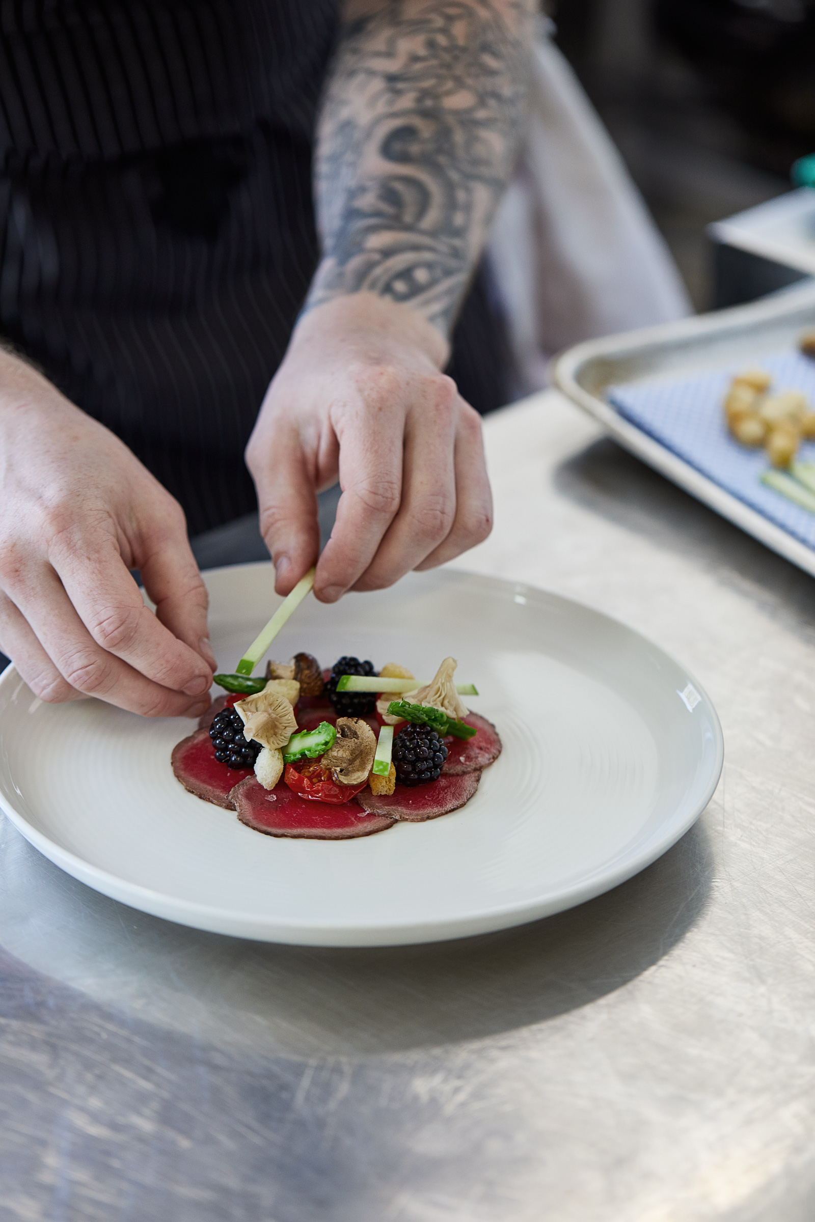 Chef Euan plating Venison Carpaccio, kitchen reportage photography by Alastair Ferrier, Glasgow food and drink photographer